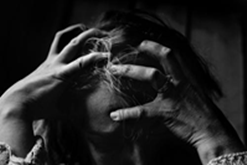 A stressed lady with her head in her hands