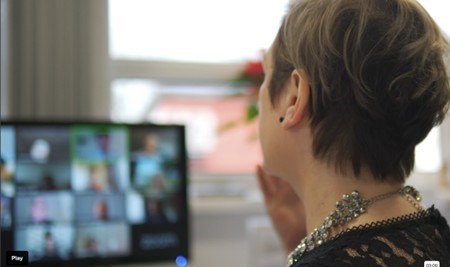 A lady on an online call with multiple people